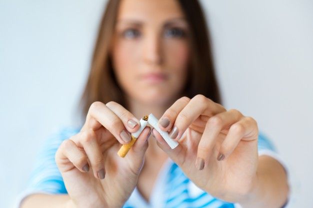 Femme brisant une cigarette en deux.