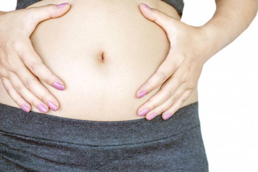 Femme tenant son ventre gonflé car prise de poids.