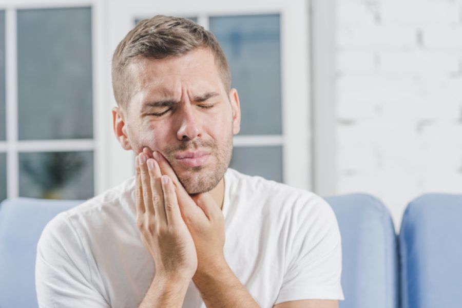 Homme se tanant les machoires de douleur, représentant les maladies parodontales