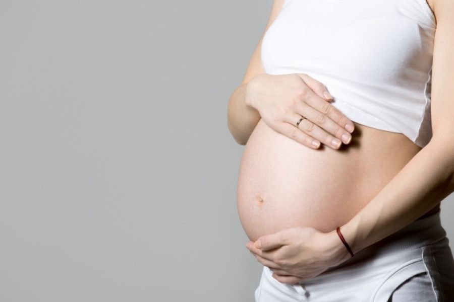 Femme enceinte tenant son ventre.